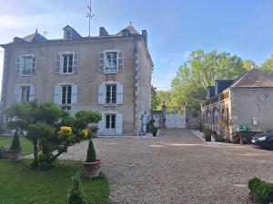 an old house with a driveway in front of it at Chambre d'hotes Les Rives de la Tronne in Mer