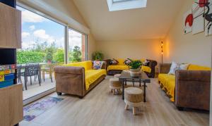 a living room with yellow furniture and a large window at Vue sur lac in Dienville