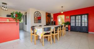 a dining room with red walls and a table and chairs at Vue sur lac in Dienville