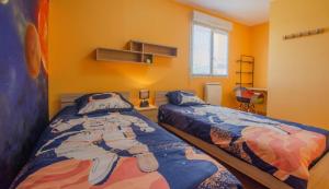 a bedroom with two beds in a room with yellow walls at Vue sur lac in Dienville