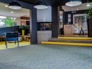 a lobby with a blue and yellow floor and lights at ibis Styles Chalon sur Saône in Chalon-sur-Saône +93 photos