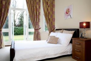 a bedroom with a white bed and a window at Sherborne House, City Centre Victorian Apartments in Basingstoke