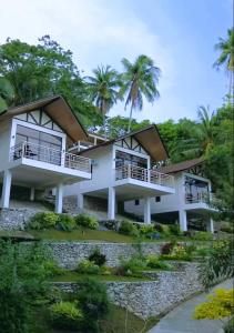 aominium building with balconies and palm trees at Island Garden Beach Resort in Samal
