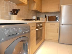 een keuken met een wasmachine bij Sherborne House, City Centre Victorian Apartments in Basingstoke