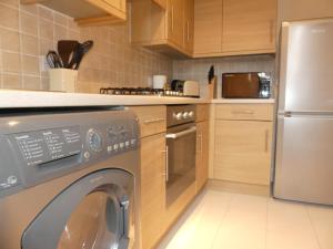 a kitchen with a washing machine in a kitchen at Basingstoke Apartments - Sherborne House, City Centre Victorian Apartments in Basingstoke