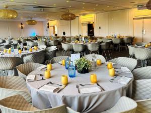a banquet hall with tables and chairs with yellow candles at Novotel Marne La Vallée Collégien in Collégien +64 photos