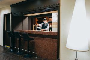 a man standing at a bar in a restaurant at Hamamatsu Station Hotel in Hamamatsu