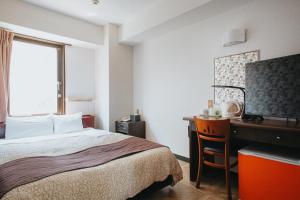 a hotel room with a bed and a desk and a window at Hamamatsu Station Hotel in Hamamatsu +109 photos