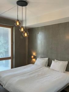 a bedroom with a large white bed with two pillows at Tikka Apartments in Jyväskylä