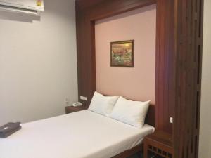 a bedroom with a white bed and a picture on the wall at Suanrak Resort in Suphan Buri +23 photos