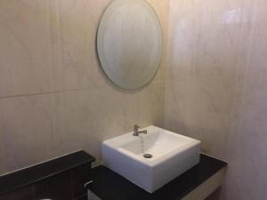 a bathroom with a white sink and a mirror at Suanrak Resort in Suphan Buri
