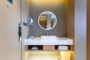 a bathroom with a sink and a mirror at 库尔勒孔雀河景观带滨河西路亚朵酒店 in Korla +23 photos