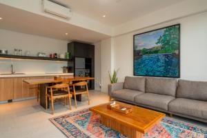 a living room with a couch and a table at CASA MIA - Luxury Apartments Central Kuta in Kuta Lombok