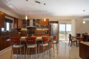 a kitchen with a table and chairs and a refrigerator at Elysian View Estate in Faliraki