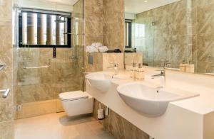 a bathroom with two sinks and a shower at CASA MIA - Luxury Apartments Central Kuta in Kuta Lombok +70 photos