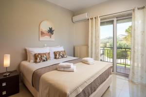 a bedroom with two beds and a balcony at Elysian View Estate in Faliraki +71 photos