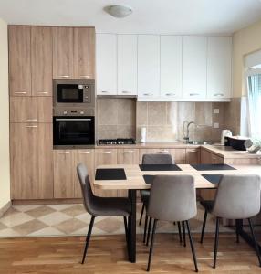 a kitchen with a table with chairs and a microwave at Urban Retreat in Osijek