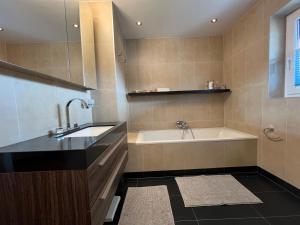 a bathroom with a bath tub and a sink at chapter-one in Innsbruck