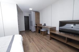 a bedroom with a bed and a desk and a television at mh town in Ulaanbaatar
