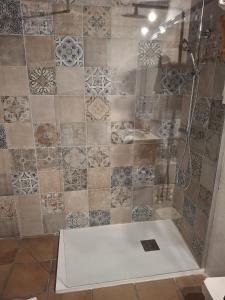 a bathroom with a shower with a tile wall at Posada Campo in Suances
