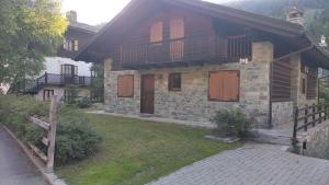 an old stone house with a porch and balcony at Hygge Chalet a Champoluc in Champoluc +3 photos