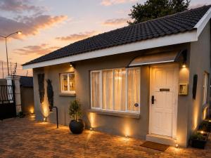 a house with a white door and a potted plant at Phola Lodge OR Tambo in Kempton Park