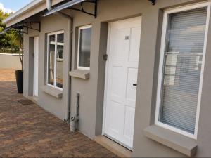 a white door on a house with windows at Phola Lodge OR Tambo in Kempton Park