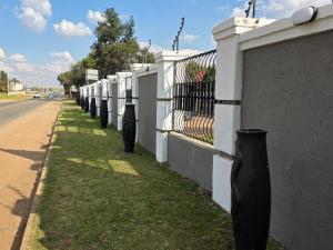 a row of parking meters on the side of a fence at Phola Lodge OR Tambo in Kempton Park