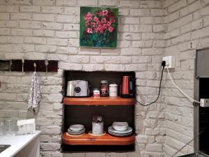 a brick wall with a shelf with plates and a vase of flowers at Cozy Cork Cottage - Sleeps 4 in Beacon Bay +41 photos