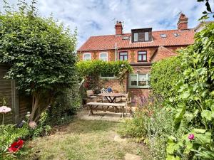 a house with a picnic table in the garden at Carrstone Cottage, Snettisham in Snettisham