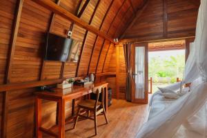 a room with a desk and a tv on the wall at Bunut Bungalow in Nusa Penida