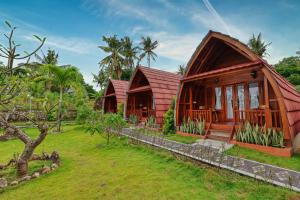 a house with a red roof and a yard at Bunut Bungalow in Nusa Penida