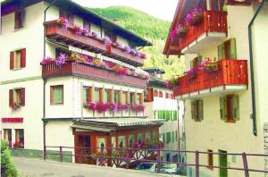 eine Gruppe von Gebäuden mit Blumen auf ihren Balkonen in der Unterkunft Alpina depandance in Castello Tesino