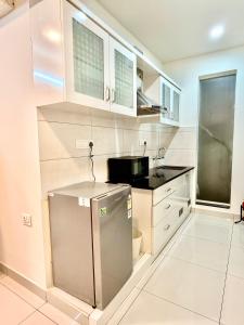 a kitchen with a sink and a refrigerator in it at The Staying Co in Bangalore