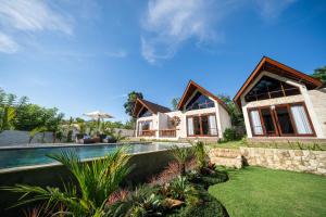 a house with a swimming pool in a yard at Nayandra Uluwatu in Uluwatu