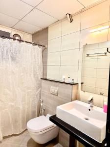 a bathroom with a white toilet and a sink at The Staying Co in Bangalore +21 photos