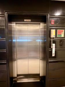 a metal elevator in a building with a phone at The Staying Co in Bangalore