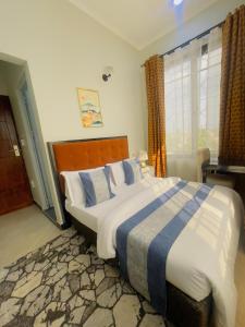a bedroom with a large bed and a window at Diary Hotel in Dar es Salaam +5 photos