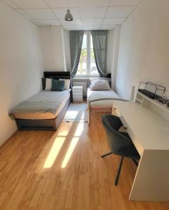 a room with two beds and a desk in it at Tolle Stadtwohnung in Darmstadt +4 photos