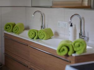 a kitchen counter with green towels on a sink at Chalet near Passthurn Ski Area Kitzbühel in Mittersill +35 photos