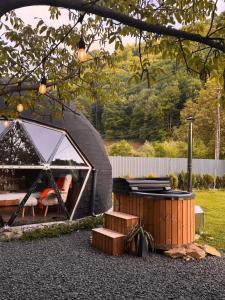 ein Kuppelhaus mit Whirlpool im Garten in der Unterkunft Riverside Dome - Glamping Transalpina in Dobra