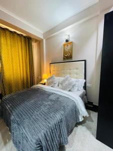 a bedroom with a large bed with a blue blanket at Diary Hotel in Dar es Salaam