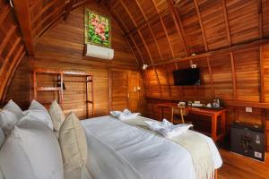 a bedroom with a large white bed in a room at Bunut Bungalow in Nusa Penida +60 photos