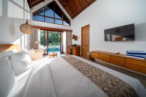 a bedroom with a large white bed and a tv at Nayandra Uluwatu in Uluwatu +72 photos
