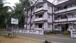 a purple building with a sign in front of it at Jasmine Guest House in Majorda