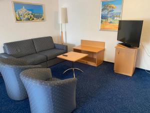 a living room with a couch and a tv at My Home Location in La Chaux-de-Fonds