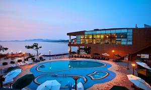 a resort with a swimming pool in front of a building at Eldorado Resort in Sinan