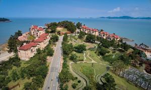 an aerial view of a house on a hill next to the water at Eldorado Resort in Sinan