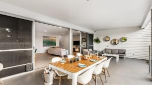 a dining room and living room with a table and chairs at Wave Whisperer Retreat in Woorim