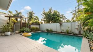 a swimming pool in a backyard with a fence at Wave Whisperer Retreat in Woorim